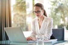 Mujer sentada mirando el computador, esta observando un informe
